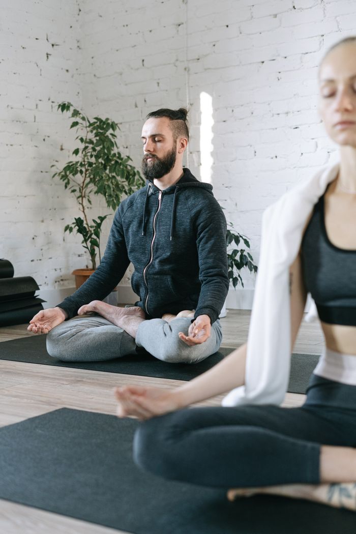The Art of Drawing Readers In: Your attractive post title goes here Serene indoor yoga practice with a man and woman in meditation pose.