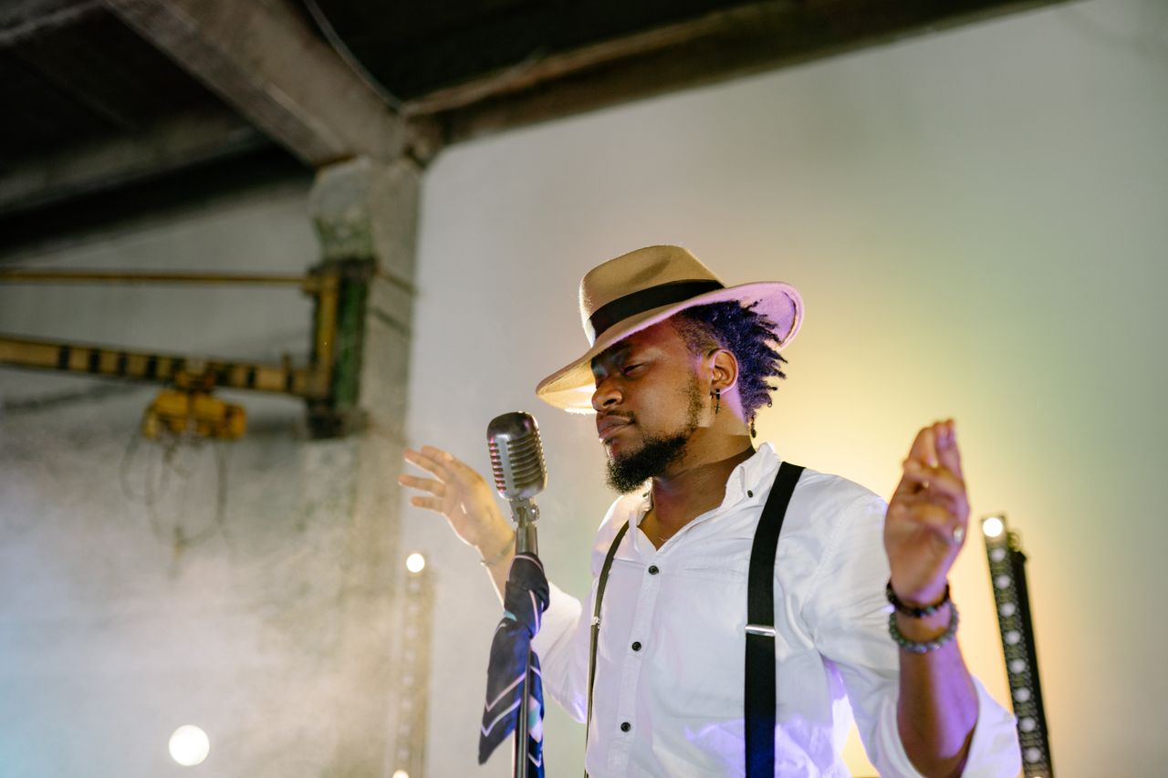 about-us A passionate musician sings on stage with a vintage microphone and stylish hat.